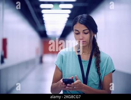 Female technician looking at smart phone in data center Stock Photo