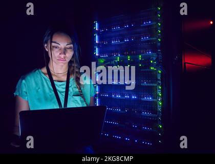 Technician using laptop in server room Stock Photo