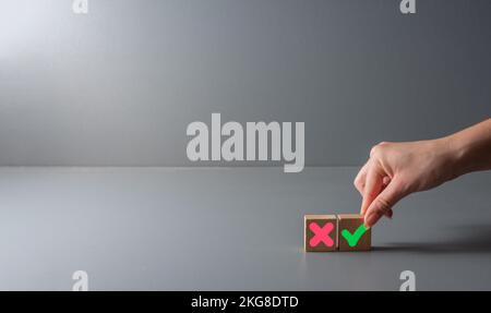 pros and cons or for and against concept , green check mark and a red cross on wooden blocks , background . Stock Photo