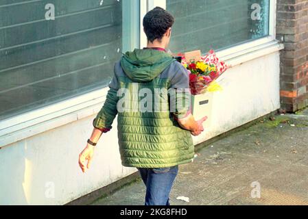 young man holding a bunch of flowers Stock Photo