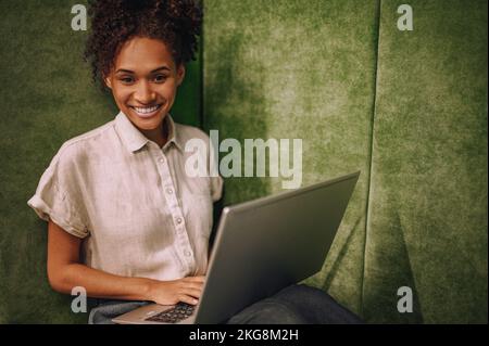 High-spirited female with her laptop looking ahead Stock Photo