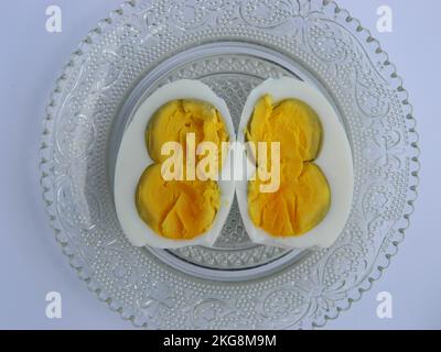 The top view of a cooked twin egg cut in half served on a patterned plate Stock Photo