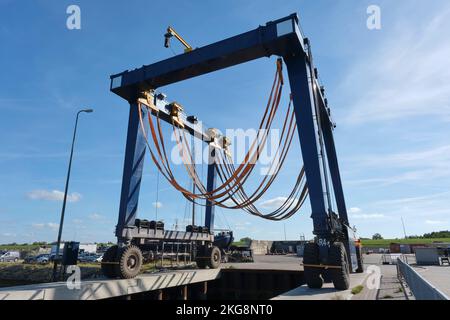 Large empty mobile boat travel lift in a harbour under a blue sky. Yacht Service in a yacht marina. Lifts large boats for maintenance and repaint Stock Photo