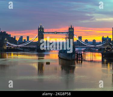 A golden sunrise over the River Thames with tower bridge and HMS Belfast, Long exposure. Stock Photo