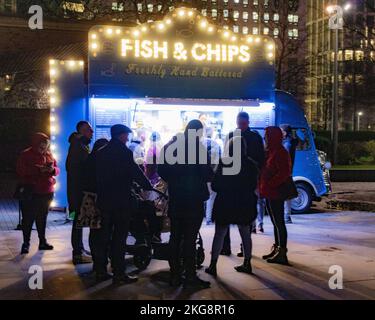 A crowd of people queuing at a Fish and Chips van on the south bank, ay night in London, England Stock Photo