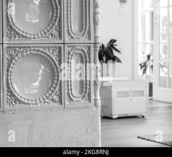 Modern interior with luxury ceramic tiles of an Alsatian Masonry heater Kachelofen with air purifier in background- black and white image Stock Photo