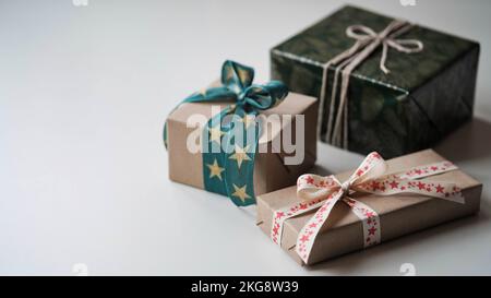 Close-up of three gift boxes with beautiful bows of ribbons with a pattern of stars on a white background,copy space.Festive gift wrapping,preparation Stock Photo
