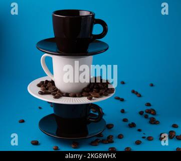 photo coffee cups in a vertical row on a blue background Stock Photo