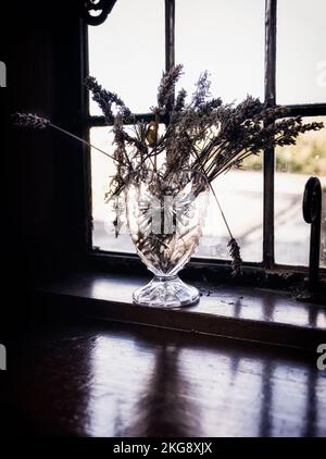 Dried lavender with broken strands in a cut crystal vase on a cottage windowsill at the Black Country Museum. Stock Photo