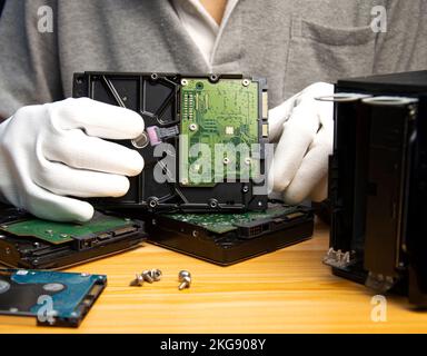 3.5 inch hard drive is still popular today, technician holding hard drive in hand Stock Photo