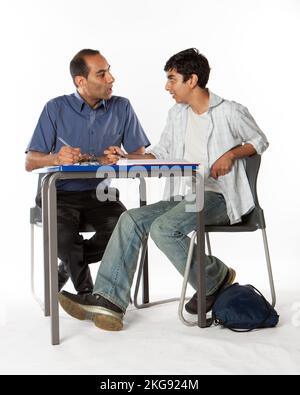 Teenagers: Individual Tuition. A South Asian teacher and his Indian student working together on an academic problem. From a series of related images. Stock Photo