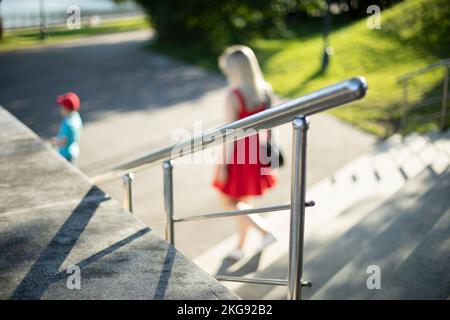 Handrail on stairs in park. Steel handrail. Element of park architecture. Metal pipe. Stock Photo