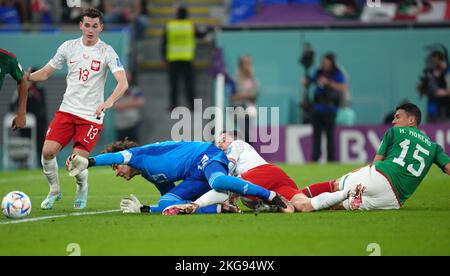 Mexico's Hector Moreno (right) fouls Poland's Robert Lewandowski, resulting in a penalty during the FIFA World Cup Group C match at Stadium 974, Rass Abou Aboud. Picture date: Tuesday November 22, 2022. Stock Photo