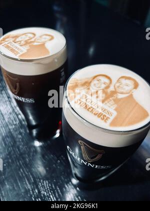 A pint of Guinness as a stoutie with image of a young couple printed on the head Stock Photo