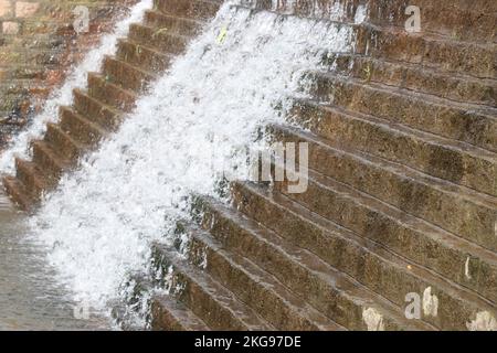 Water is flowing on steps that is built on a small overflow dam used to store and provide water for dry season Stock Photo