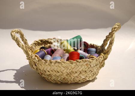 Wicker basket with balls of knitting yarn on white background, close up Stock Photo