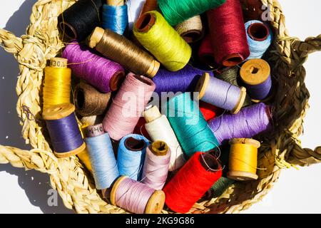 Wicker basket with balls of knitting yarn on white background, close up Stock Photo