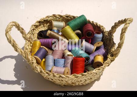 Wicker basket with balls of knitting yarn on white background, close up Stock Photo