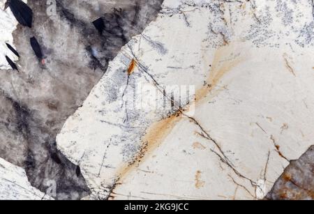 White marble with veins and gray-brown inclusions. Stock Photo
