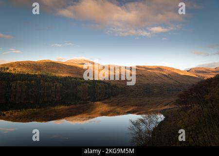 A sunny, still autumnal HDR image of reflections hills and forest in Loch More in the Reay Forest, northwest Sutherland, Scotland. 24 October 2022 Stock Photo