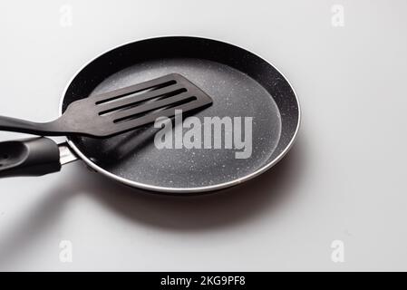 Empty pan on white background. Fried pan with spatula Stock Photo