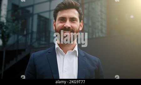 Elegant successful caucasian businessman wearing formal suit happy male portrait of adult 30s employee bearded middle eastern attractive man posing Stock Photo