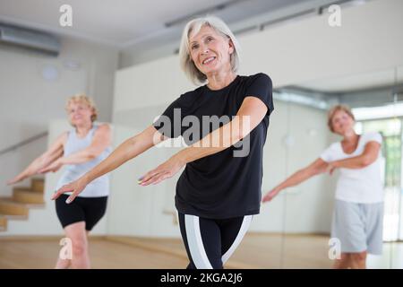 Active mature woman learning dynamic dances in choreography class Stock Photo
