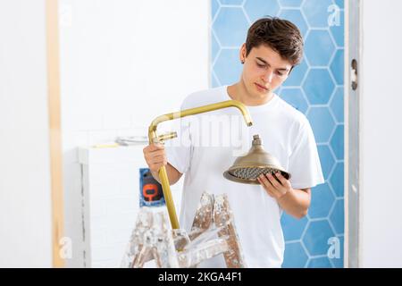 Guy preparing new shower for installation in building under construction Stock Photo