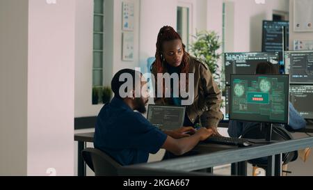 Team of coders writing data and encountering system crash, dealing with security breach warning. IT engineers having unexpected server error and no access to database, hacking attack. Stock Photo