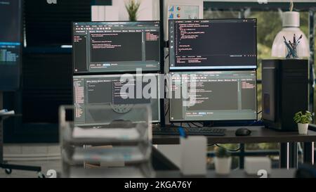 Multiple screens showing programming code in empty software it agency desk, parsing database algorithms and html text. Artificial intelligence network servers cloud computing in coding room. Stock Photo