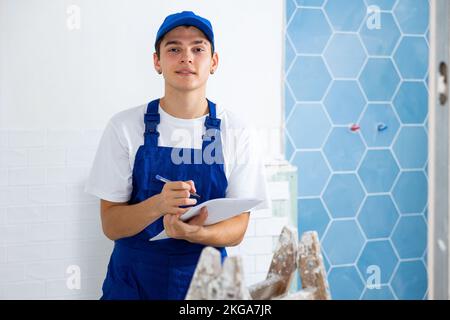 Young foreman making task list during works in building under construction Stock Photo