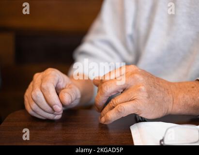 Man hands resting on a wooden table. Close up of Hands of a man. Male hands. Selective focus, blurred Stock Photo