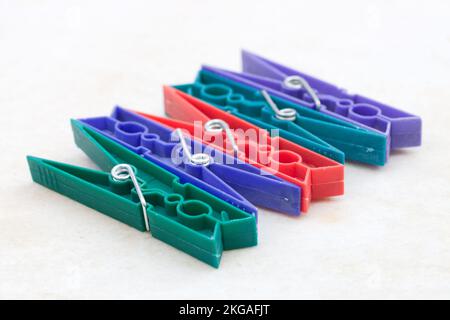 Image of a group of various colored plastic clothespins used to hang clothes on a white background Stock Photo