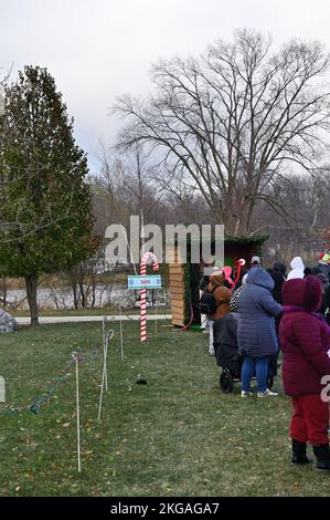 South Elgin, Illinois, USA. Long line of parents with children waiting to see Santa Claus on a very cold and blustery day. Stock Photo