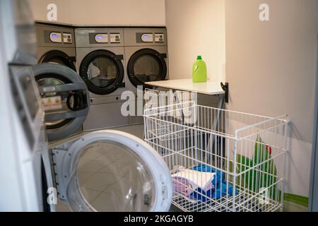 Row of front-loading washers in a laundry facility Stock Photo