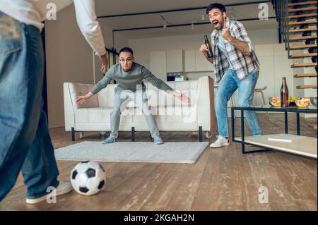 Young man supporting his buddies during the indoor sports game Stock Photo