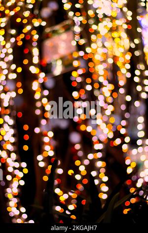 Vertical image of colored lights with bokeh effect on a dark background for celebrations, Christmas or New Year Stock Photo