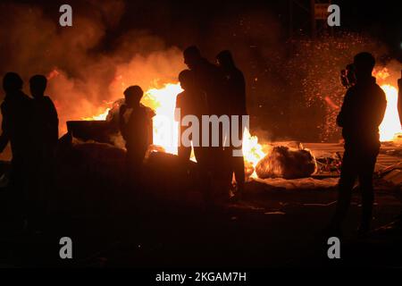 Nablus, Palestine, 22/11/2022, Palestinian demonstrators burn tires and block the road leading to Joseph's Tomb in the city of Nablus in the occupied West Bank. Demonstrators made a bold move to prevent Israeli settlers from going to Joseph's Tomb after staging demonstrations, attacking Palestinian property, and closing the streets surrounding the city of Nablus. This tomb has long been at the center of conflict between Jews, Christians, and Muslims. Some Jews believe that Biblical Joseph is buried in the grave; Muslims believe that Sheikh, an Arab leader, is buried inside. The Joseph's Tomb i Stock Photo