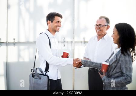 young entrepreneurs shaking hands at a chance meeting . Stock Photo