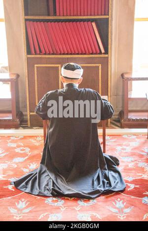 Old man reading Quran in a mosque on display Stock Photo