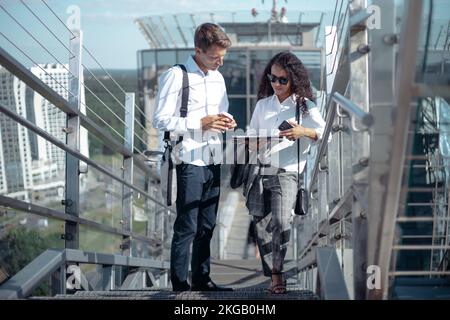 business colleagues discuss a business document standing on the steps. Stock Photo