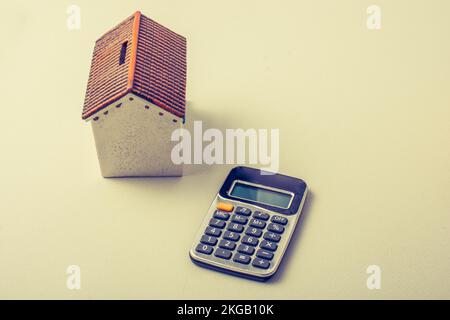 Model house and calculator placed on white background Stock Photo