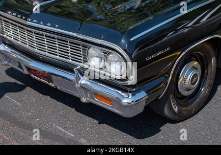 NISSWA, MN – 30 JUL 2022: Front end of a restored vintage black Chevrolet Chevelle automobile or car, with left headlights, bumper, grille and wheel. Stock Photo