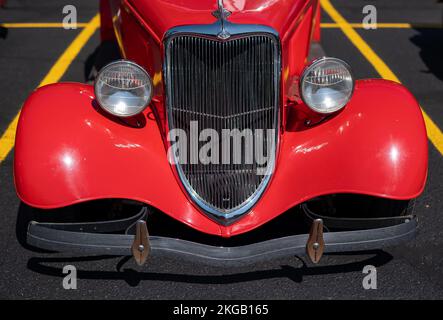 NISSWA, MN – 30 JUL 2022: Front end of red hot street rod with custom design, with bumper, headlights, grille and hood. Selective focus with shallow d Stock Photo