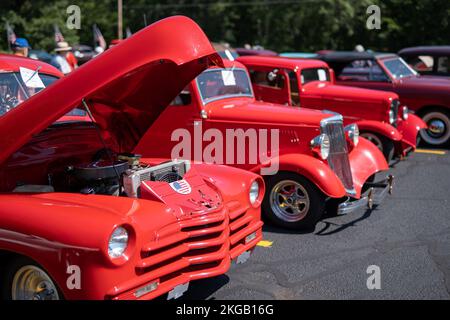 NISSWA, MN – 30 JUL 2022: Three red hot street rods with custom designs, in a row at a car show. Stock Photo