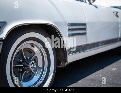 NISSWA, MN – 30 JUL 2022: Front left wheel of a restored vintage white Buick automobile or car. Selective focus with shallow depth of field. Stock Photo