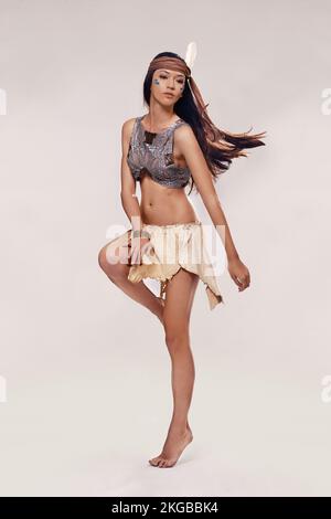 Let her captivate you with her culture. A sultry young woman in native american-inspired clothing. Stock Photo