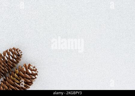 Christmas background with two pine cones isolated on a silver white background with copy space. Stock Photo