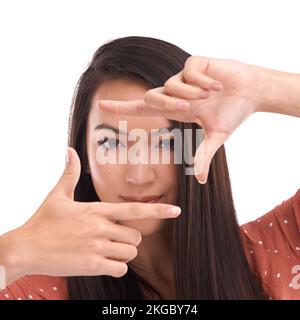 Say cheese. Closeup portrait of a beautiful girl using her hands to frame a picture of you. Stock Photo