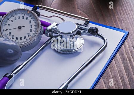 blood pressure monitor and stethoscope on clipboard with blank sheet medical concept Stock Photo